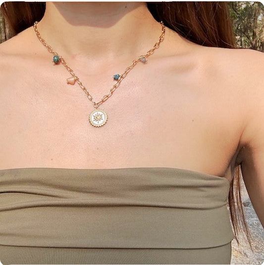 Collier doré rond blanc avec soleil et pierres des couleurs